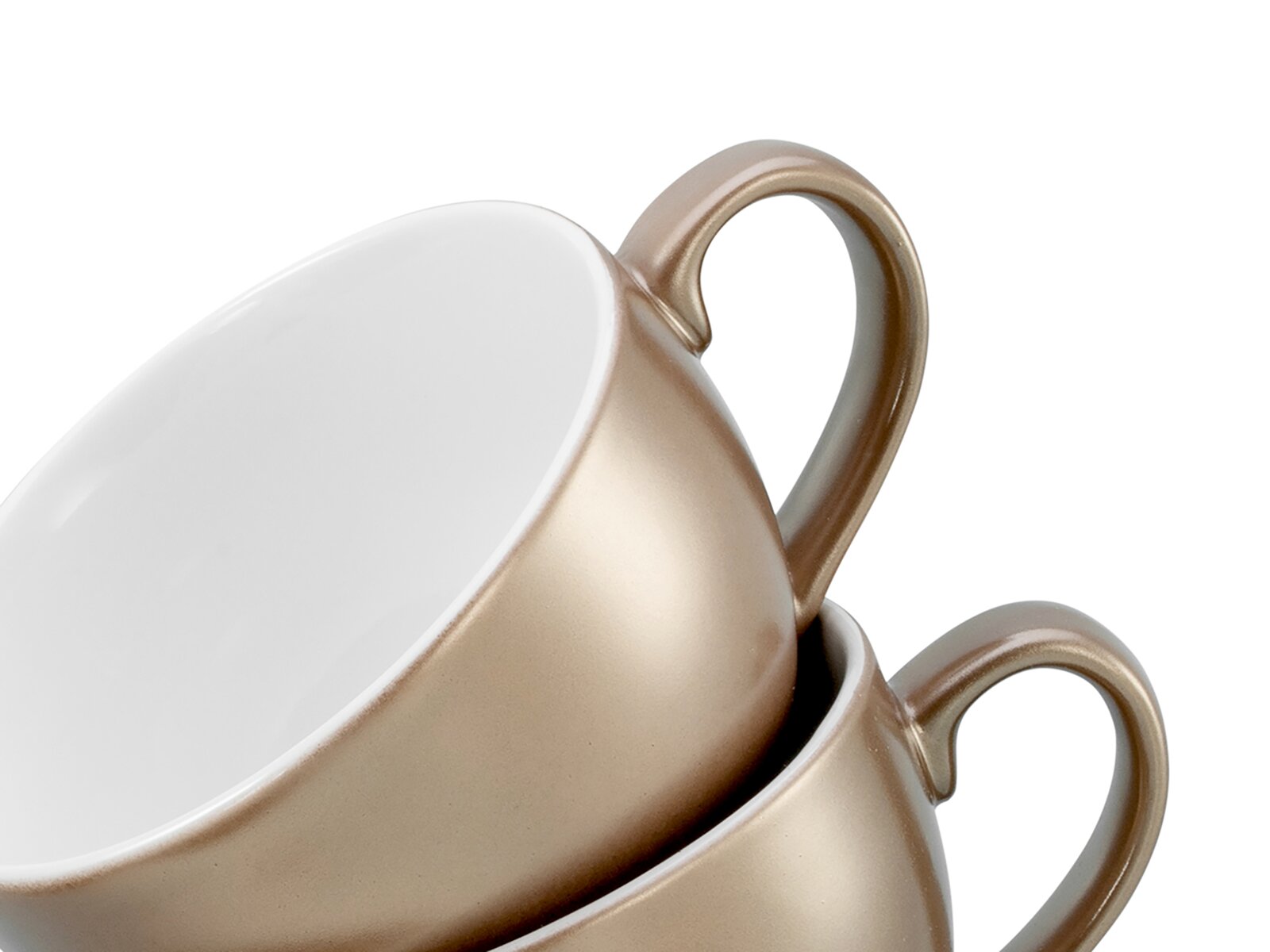 Zwei übereinander gestapelte Keramik-Kaffeetassen in Champagner/Gold mit weißer Innenseite, Nahaufnahme in schräger Seitenansicht vor weißem Hintergrund