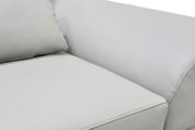 Detailaanzicht van een witte leren bank met fijn generfde bekleding, zachte kussens en verzorgde siernaden