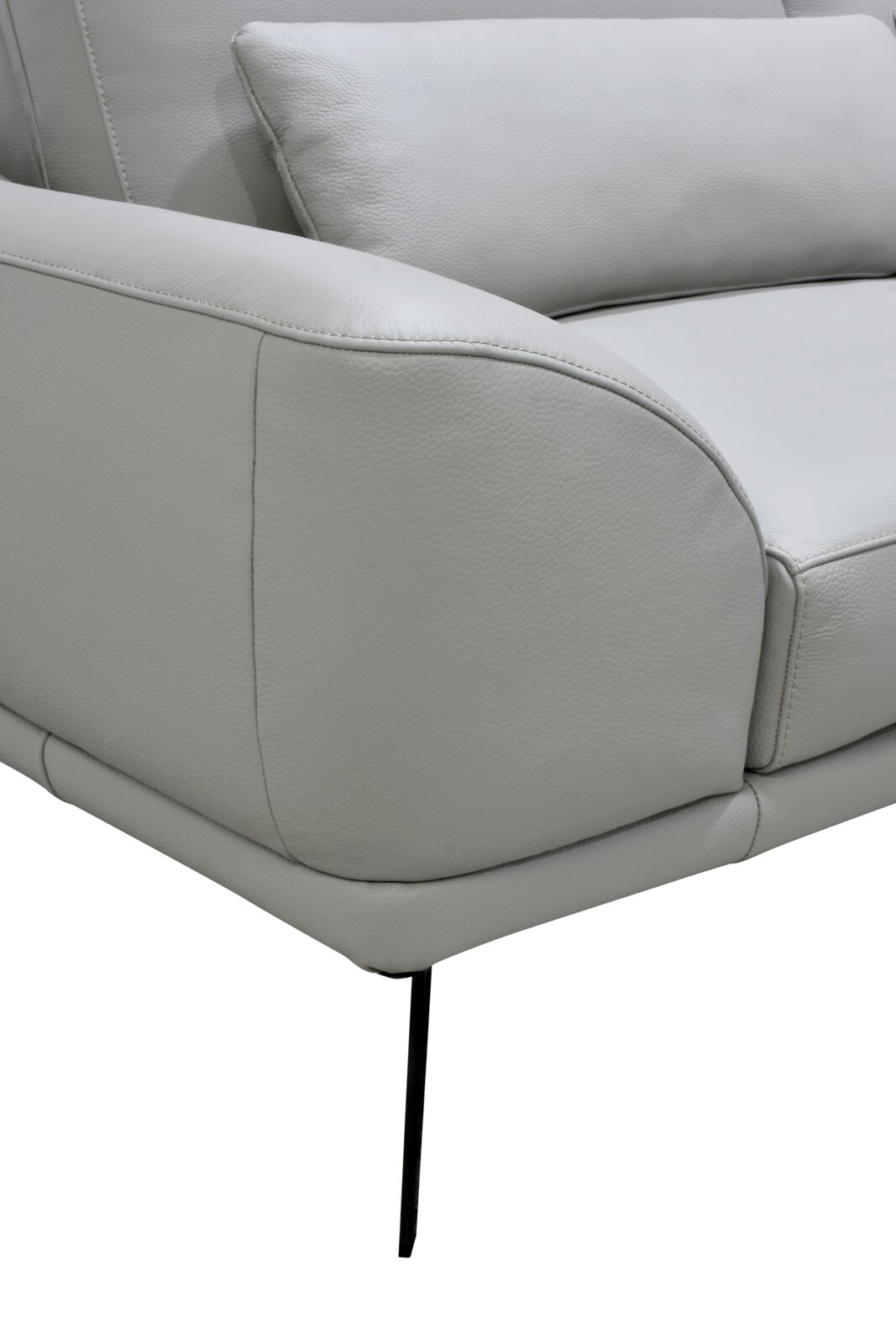 Detailaanzicht vanuit schuin vooraanzicht van een lichtgrijze fauteuil met zachte bekleding, afgeronde armleuning, sierstiksels, rugkussen en slanke zwarte metalen poot.