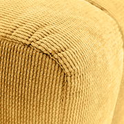 Nahaufnahme eines gelben, strukturierten Hockers mit geripptem Stoffbezug, perspektivisch von der Seite aufgenommen.