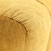 Nahaufnahme eines gelben, strukturierten Hockers mit geripptem Stoffbezug, perspektivisch von der Seite aufgenommen.