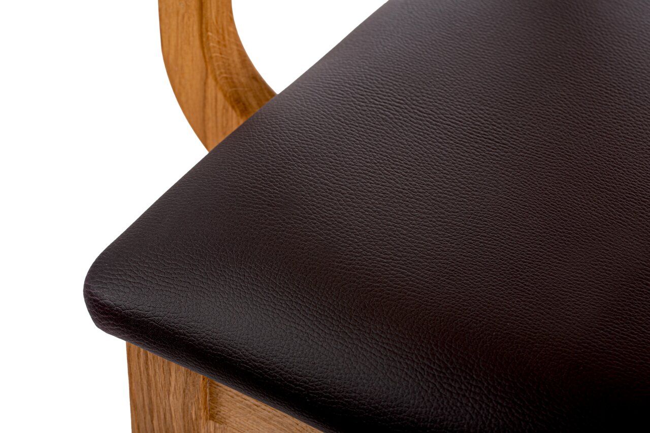 Nahaufnahme eines Sesselsitzes mit dunkelbraunem Lederbezug und Holzrahmen, von oben betrachtet.