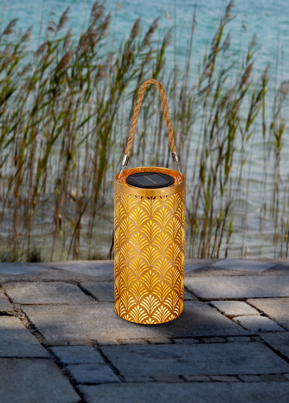 Ambia Garden Solarleuchte MARAKESH Solarbetriebene Laterne mit dekorativem Muster und Tragegriff, auf einer Terrasse mit Blick auf Schilf und Wasser.