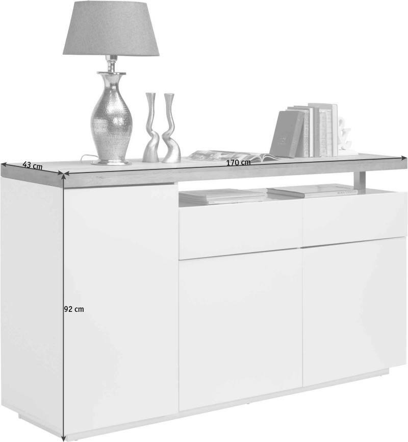 Weißes Sideboard mit zwei Türen und zwei Schubladen, dekoriert mit einer Lampe und Büchern, seitliche Perspektive.