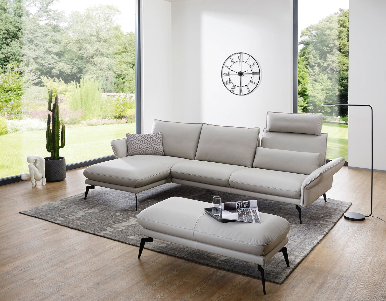 Moderano Longchairkombination AMBROSIA Moderne Longchairkombination in einem hellen Wohnzimmer mit großen Fenstern, grauem Teppich und stilvoller Dekoration. Perspektive von vorne links.