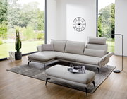 Moderne Longchairkombination in einem hellen Wohnzimmer mit großen Fenstern, grauem Teppich und stilvoller Dekoration. Perspektive von vorne links.