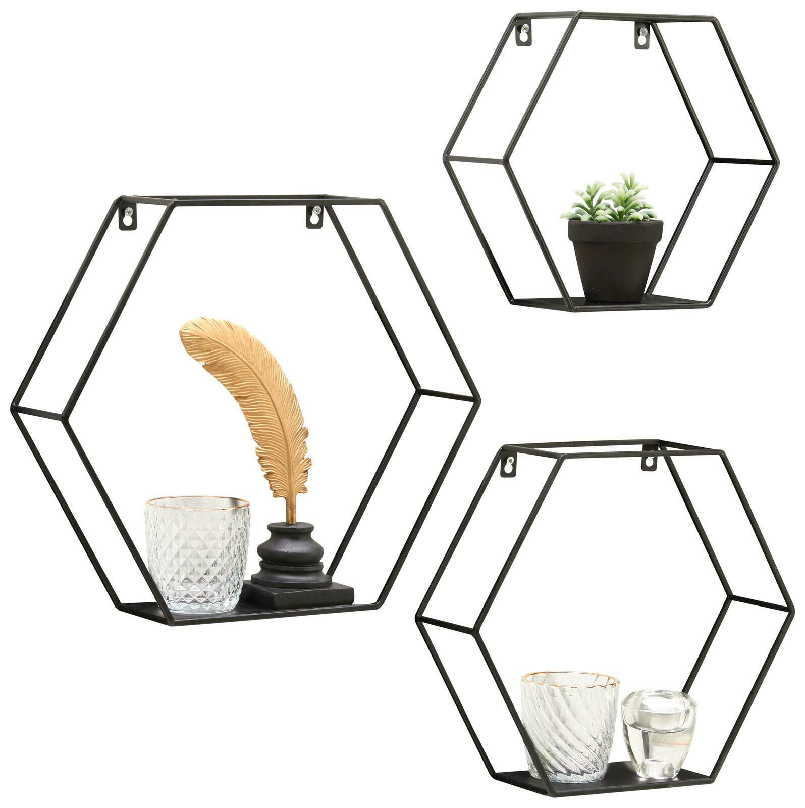 XORA Wandregal 3er Set DANA Dreiteiliges Wandregal-Set in sechseckiger Form aus schwarzem Metall, dekoriert mit Glasgefäßen, einer goldenen Feder und einer kleinen Pflanze, aus frontaler Perspektive.