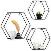 Dreiteiliges Wandregal-Set in sechseckiger Form aus schwarzem Metall, dekoriert mit Glasgefäßen, einer goldenen Feder und einer kleinen Pflanze, aus frontaler Perspektive.