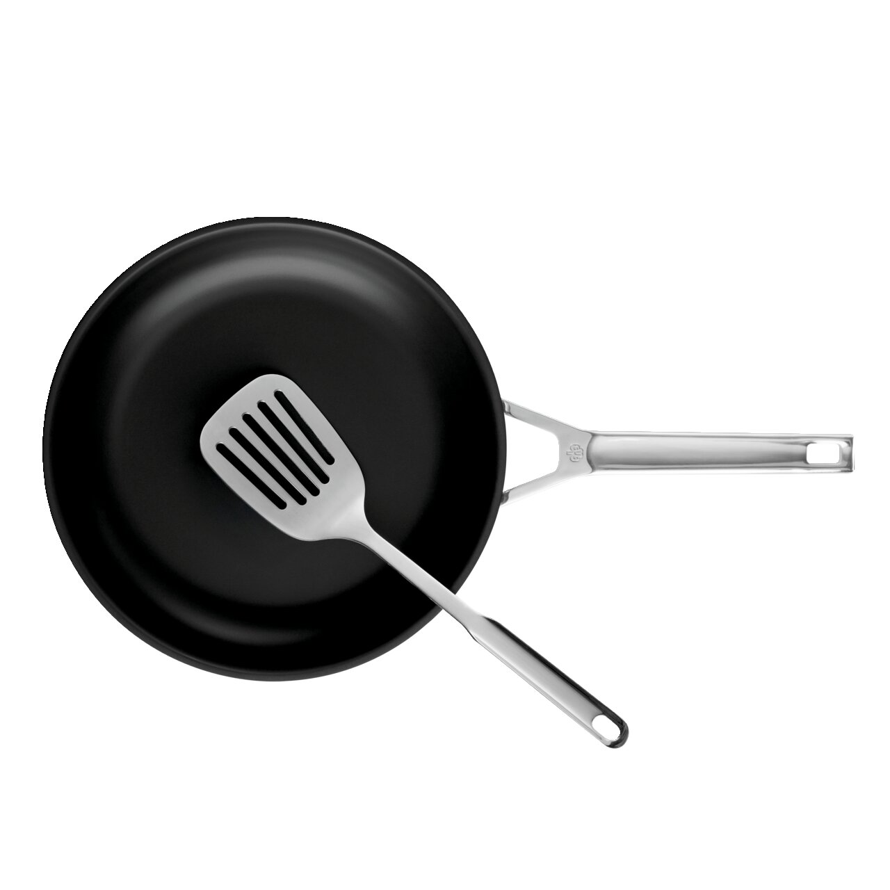 Schwarze Bratpfanne mit Edelstahlgriff und Edelstahl-Schlitzwender, Draufsicht von oben auf weißem Hintergrund
