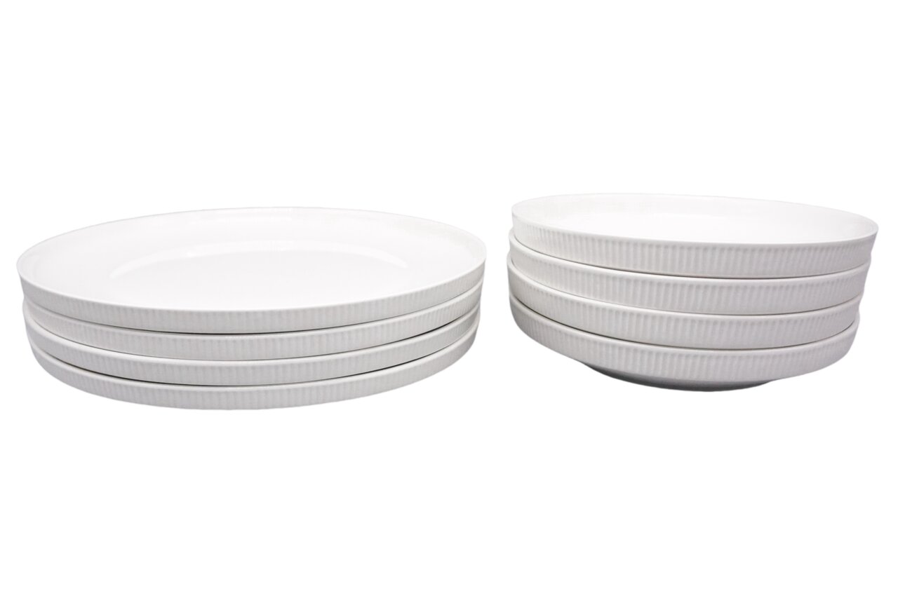 Dieter Knoll Servies 8-delig Een stapel witte, geribbelde borden en schalen uit een servies, gezien vanuit de zijkant