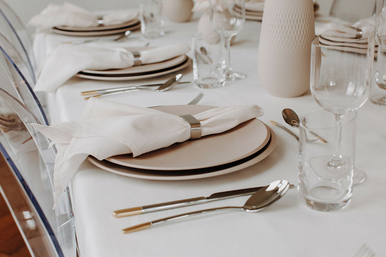 Eleganter Speiseteller NewMoon 27cm auf einem gedeckten Tisch, seitliche Perspektive.