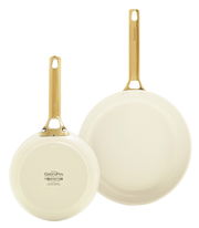 Zwei cremefarbene Bratpfannen mit goldenen Griffen, eine von oben und eine von unten gezeigt.