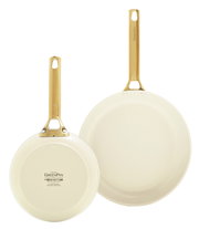Zwei cremefarbene Bratpfannen mit goldenen Griffen, eine von oben und eine von unten gezeigt.