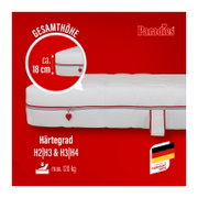 Seitliche Nahansicht einer weißen Paradies-Matratze mit Reißverschluss und rotem Herzanhänger; Gesamthöhe ca. 18 cm, Härtegrade H2/H3 und H3/H4, belastbar bis 120 kg und hergestellt in Deutschland.