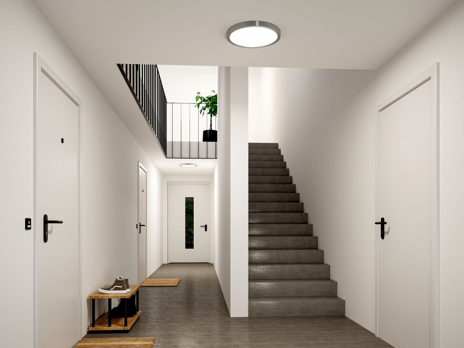 Moderne runde LED-Deckenleuchte in einem hellen Flur mit Treppe, Frontansicht leicht von unten auf die Decke