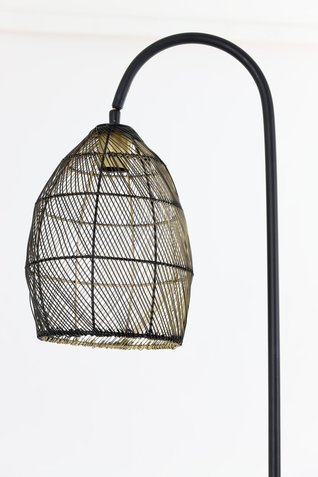 Close-up in vooraanzicht van een zwarte booglamp met een opengewerkte metalen draadkap en goudkleurige accenten.