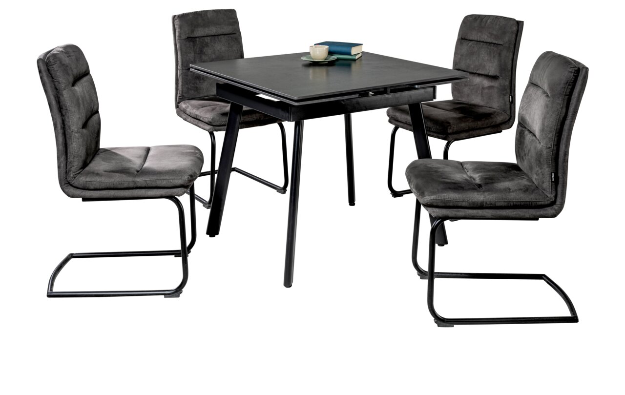 Essgruppe mit vier grauen Freischwinger-Stühlen und einem quadratischen Tisch mit dunkler Tischplatte, seitliche Perspektive