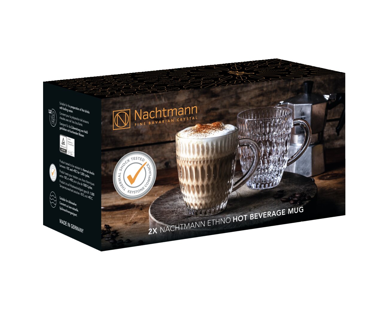 Verpakking van de Nachtmann Ethno-set van 2 glazen, met twee stijlvolle glazen, waarvan één gevuld met een warme drank, op een rustieke houten tafel. Perspectief: zijaanzicht.