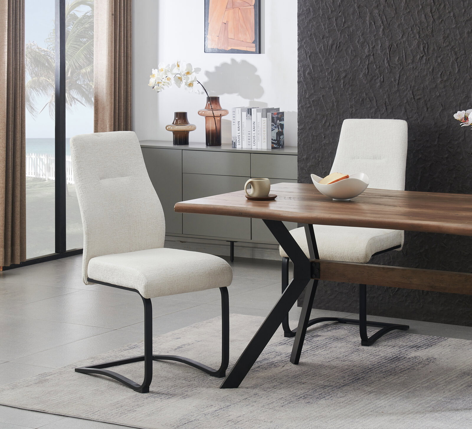 Moderner Esszimmerstuhl mit hellbeigem Stoffbezug und schwarzem Freischwinger-Metallgestell am Holzesstisch, seitliche Perspektive im Wohnambiente