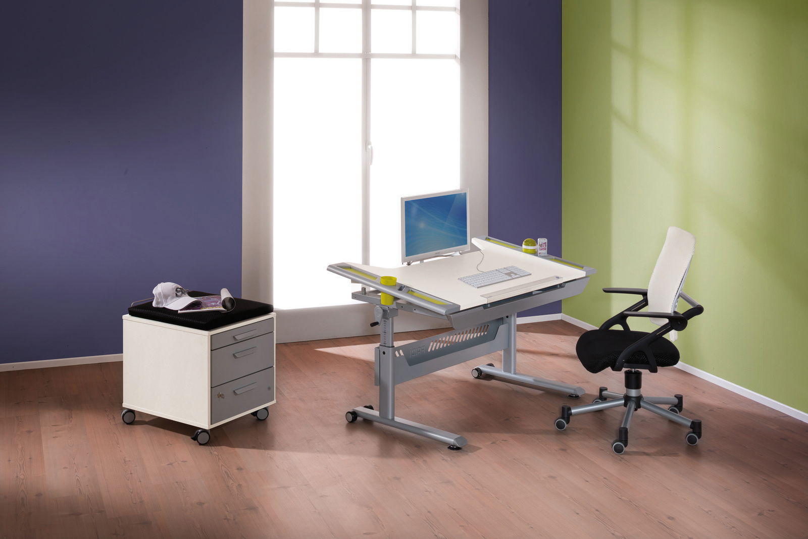 Moderner Schreibtisch mit verstellbarer Tischplatte, Computer und Bürostuhl in einem hellen Raum mit Holzfußboden, seitliche Perspektive.