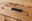 Nahaufnahme eines Holzschranks mit einer schwarzen Griffleiste, die eine elegante und moderne Optik verleiht.