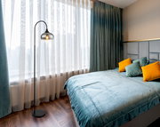 Moderne Stehleuchte in einem stilvollen Schlafzimmer mit Blick auf das Fenster.