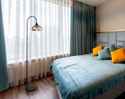 Moderne Stehleuchte in einem stilvollen Schlafzimmer mit Blick auf das Fenster.