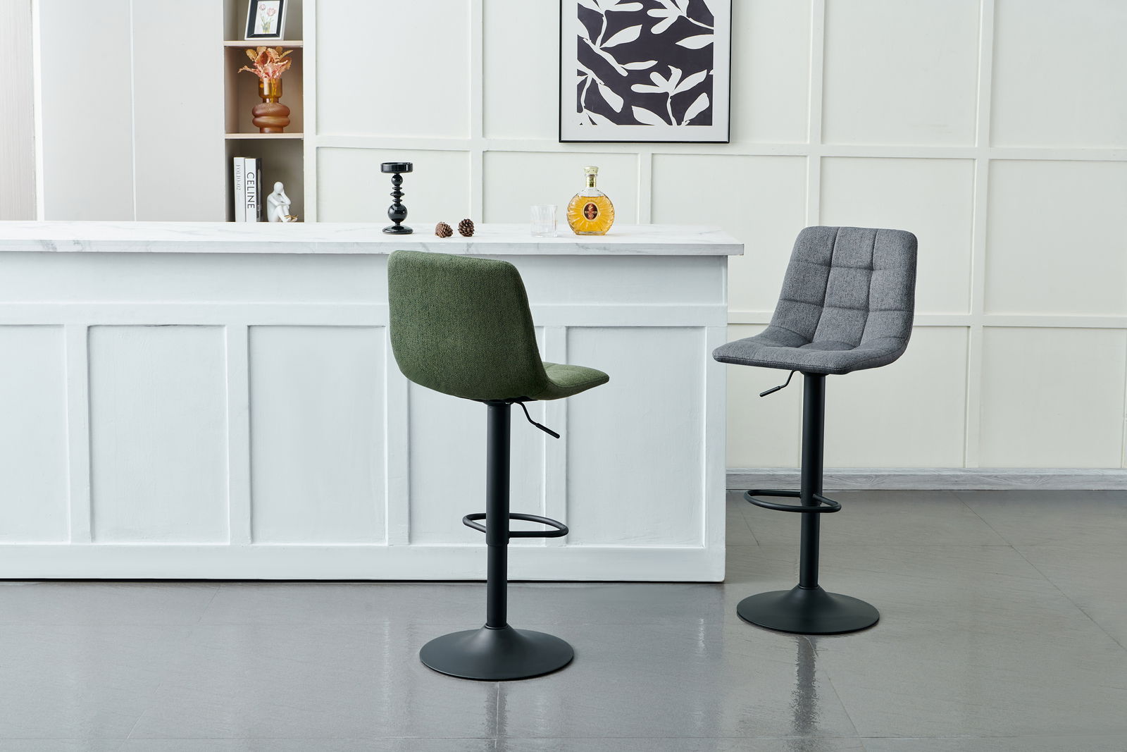 Zwei Barhocker mit gepolsterten Sitzen, einer in Grün und einer in Grau, vor einer weißen Theke in einer modernen Innenraumumgebung, seitliche Perspektive.
