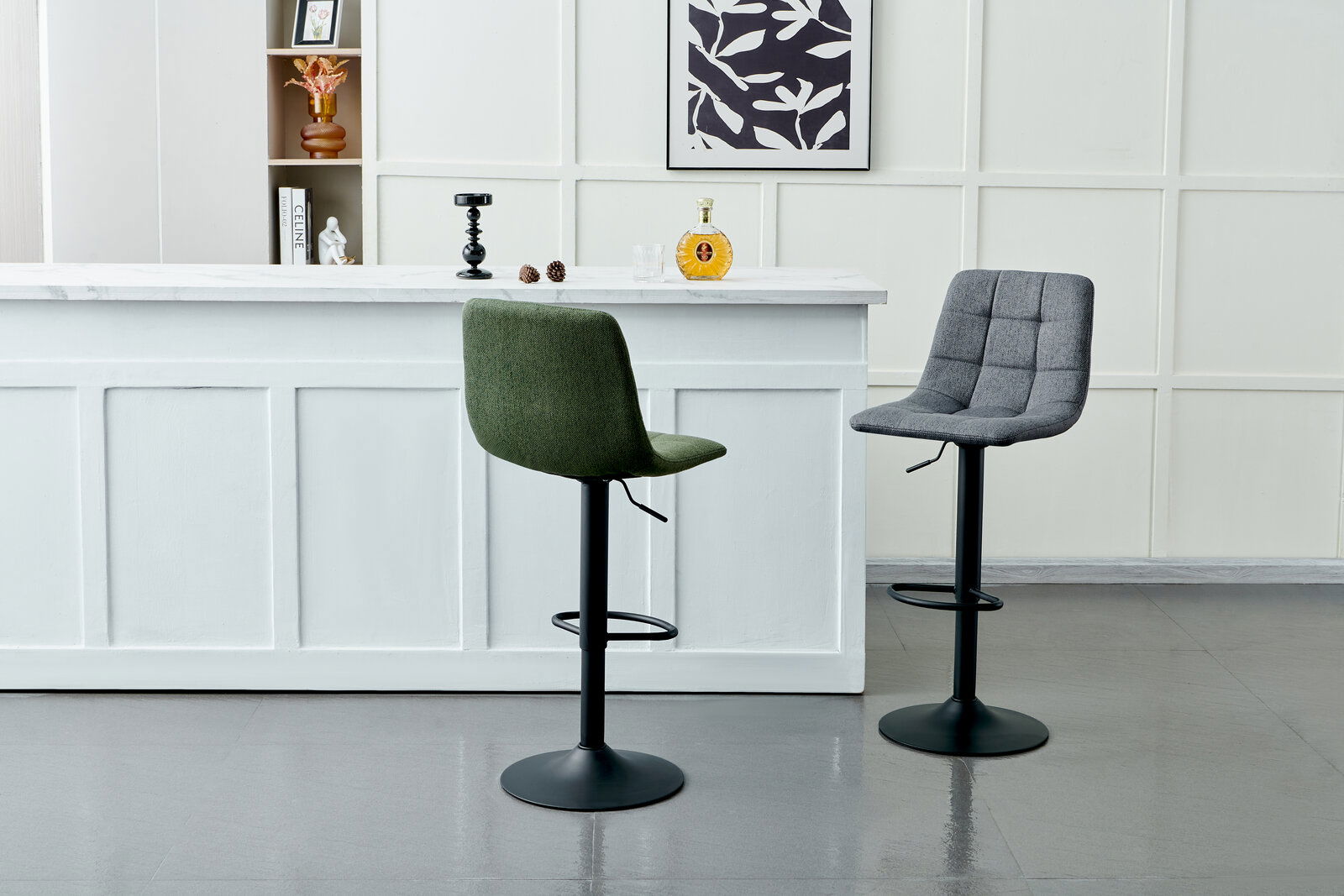 Zwei Barhocker mit gepolsterten Sitzen, einer in Grün und einer in Grau, vor einer weißen Theke in einer modernen Innenraumumgebung, seitliche Perspektive.