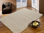 Hochflor-Teppich in einem modernen Wohnzimmer mit braunem Sessel und Holzfußboden, aus der Vogelperspektive betrachtet.