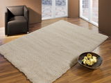 Hochflor-Teppich in einem modernen Wohnzimmer mit braunem Sessel und Holzfußboden, aus der Vogelperspektive betrachtet.