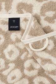 Nahaufnahme eines beigen Handtuchs mit Leopardenmuster und JOOP!-Label.