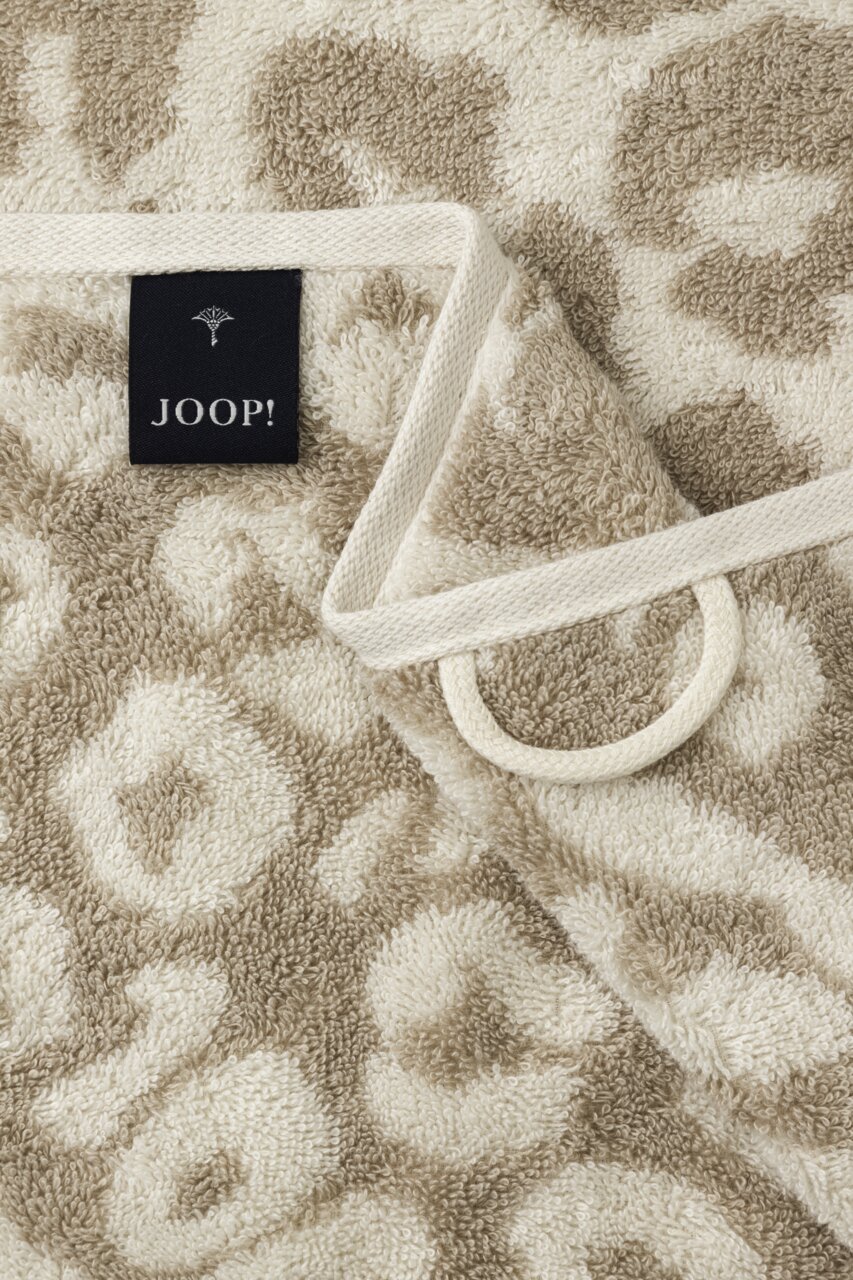 Close-up van een beige handdoek met luipaardprint en een JOOP!-label.