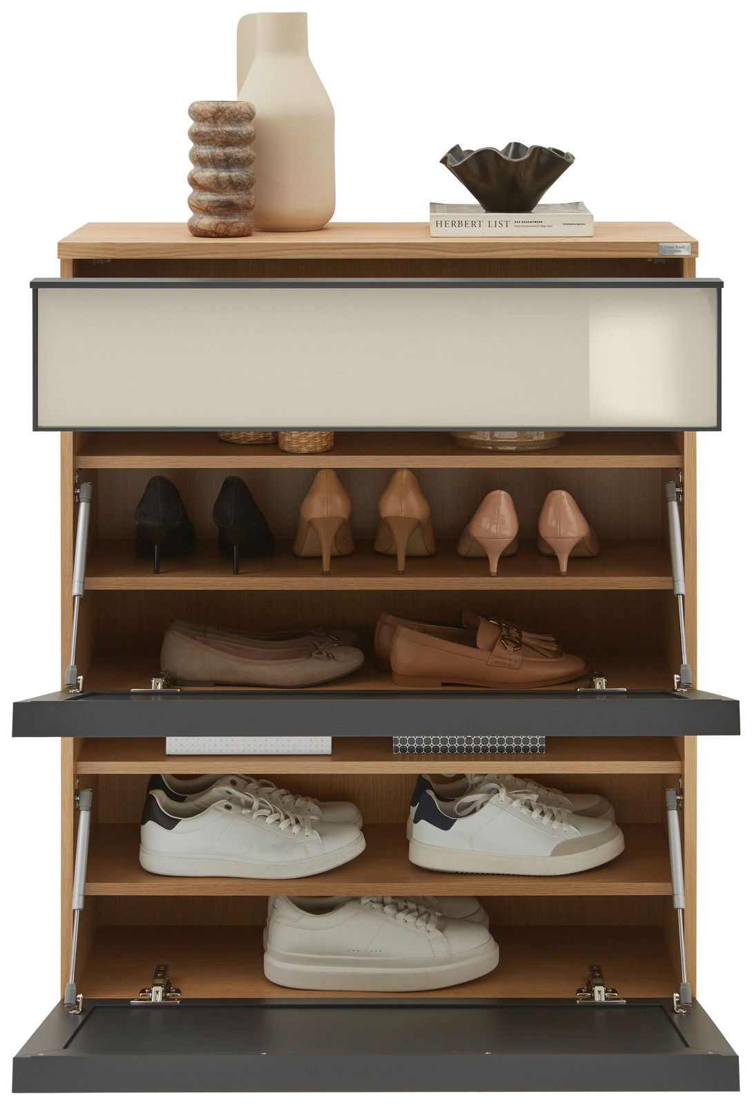 Hängeschuhschrank mit mehreren Fächern, gefüllt mit verschiedenen Schuhen, aus der Frontperspektive betrachtet. Obenauf stehen Dekorationsgegenstände wie eine Vase und Bücher.