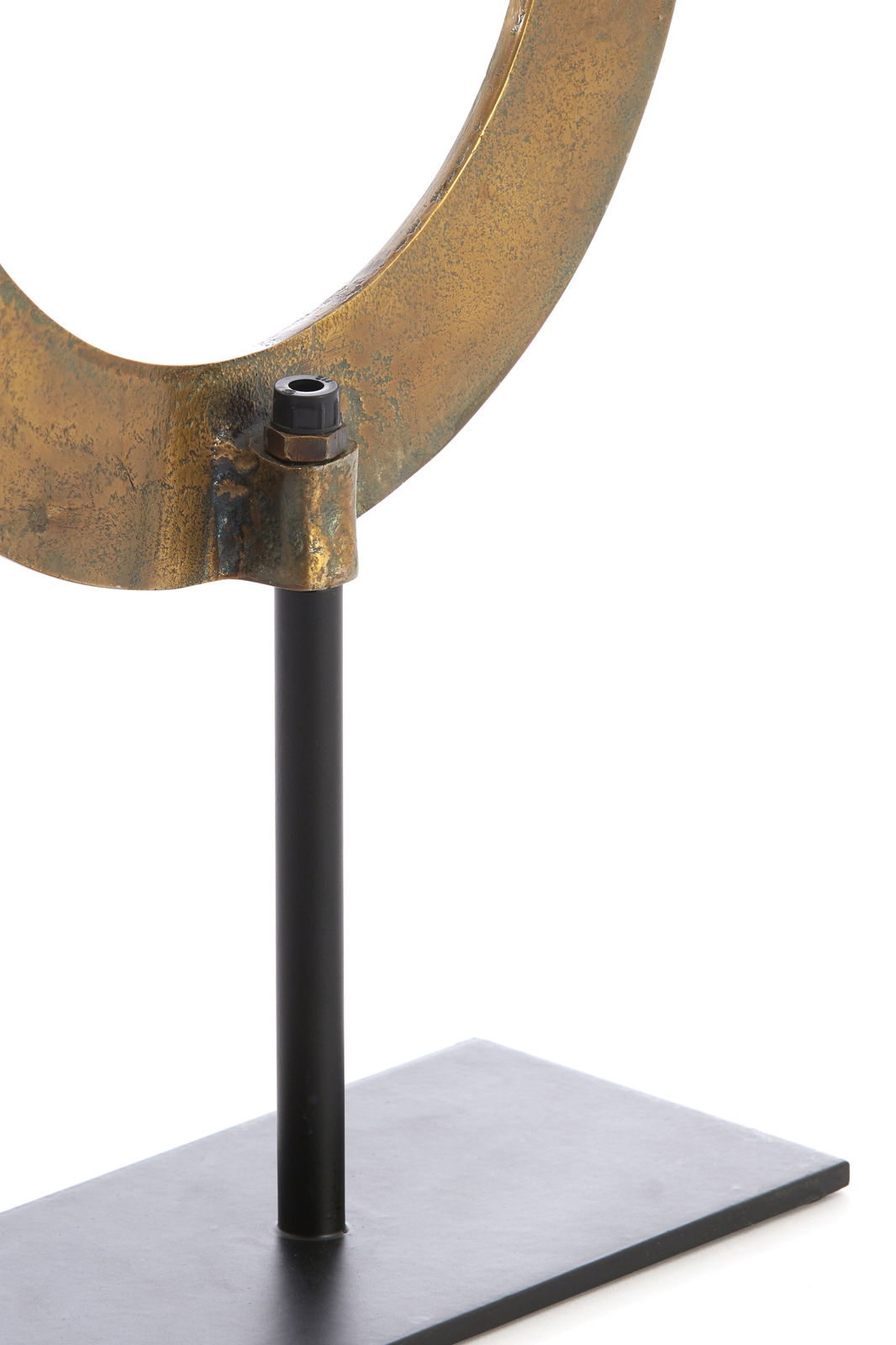 Nahaufnahme eines metallischen Ornaments in Ringform auf einem schwarzen Ständer, seitliche Perspektive.