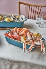 Auflaufformenset in Türkis mit Meeresfrüchten und Zitronenscheiben, seitliche Perspektive