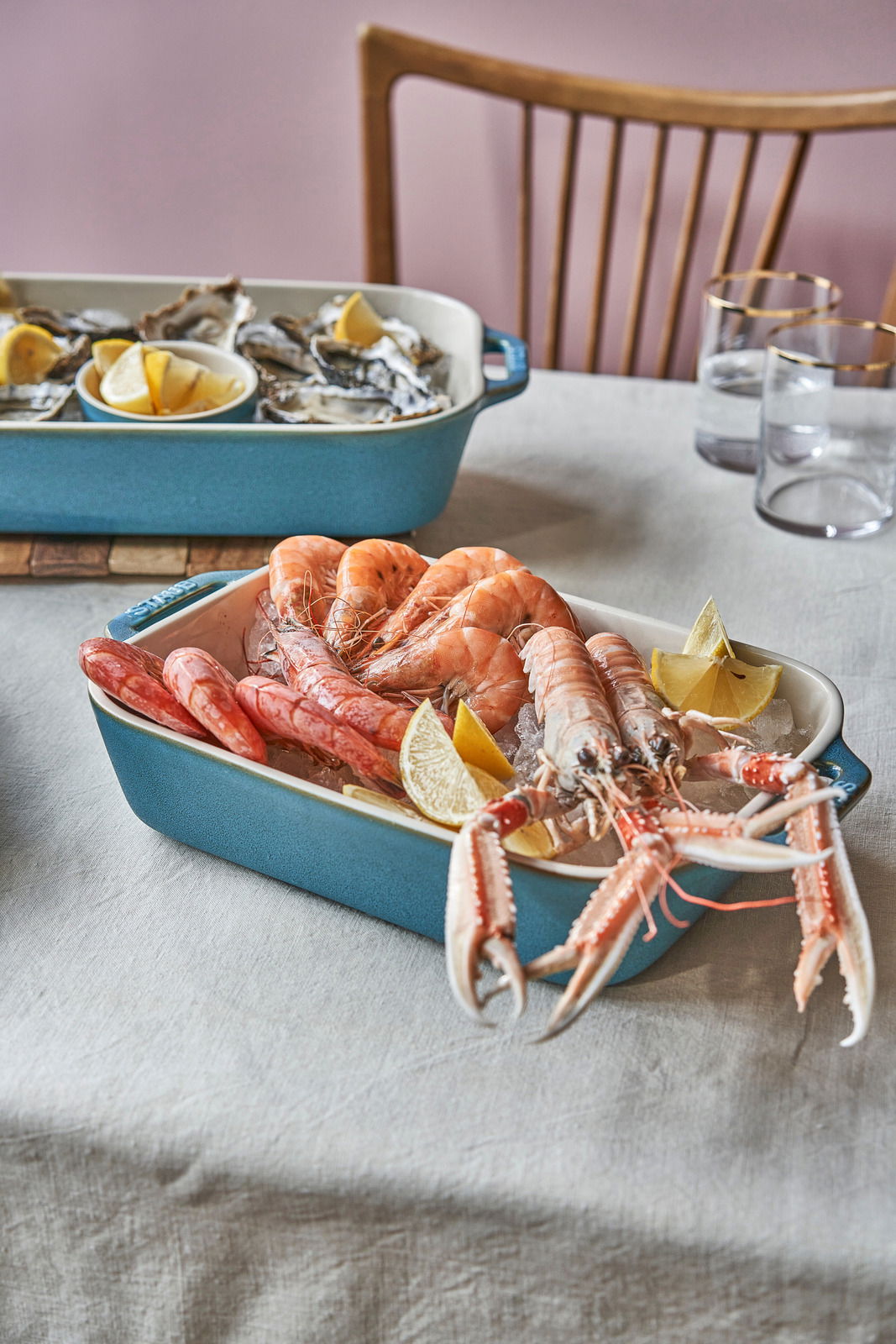 Auflaufformenset in Türkis mit Meeresfrüchten und Zitronenscheiben, seitliche Perspektive