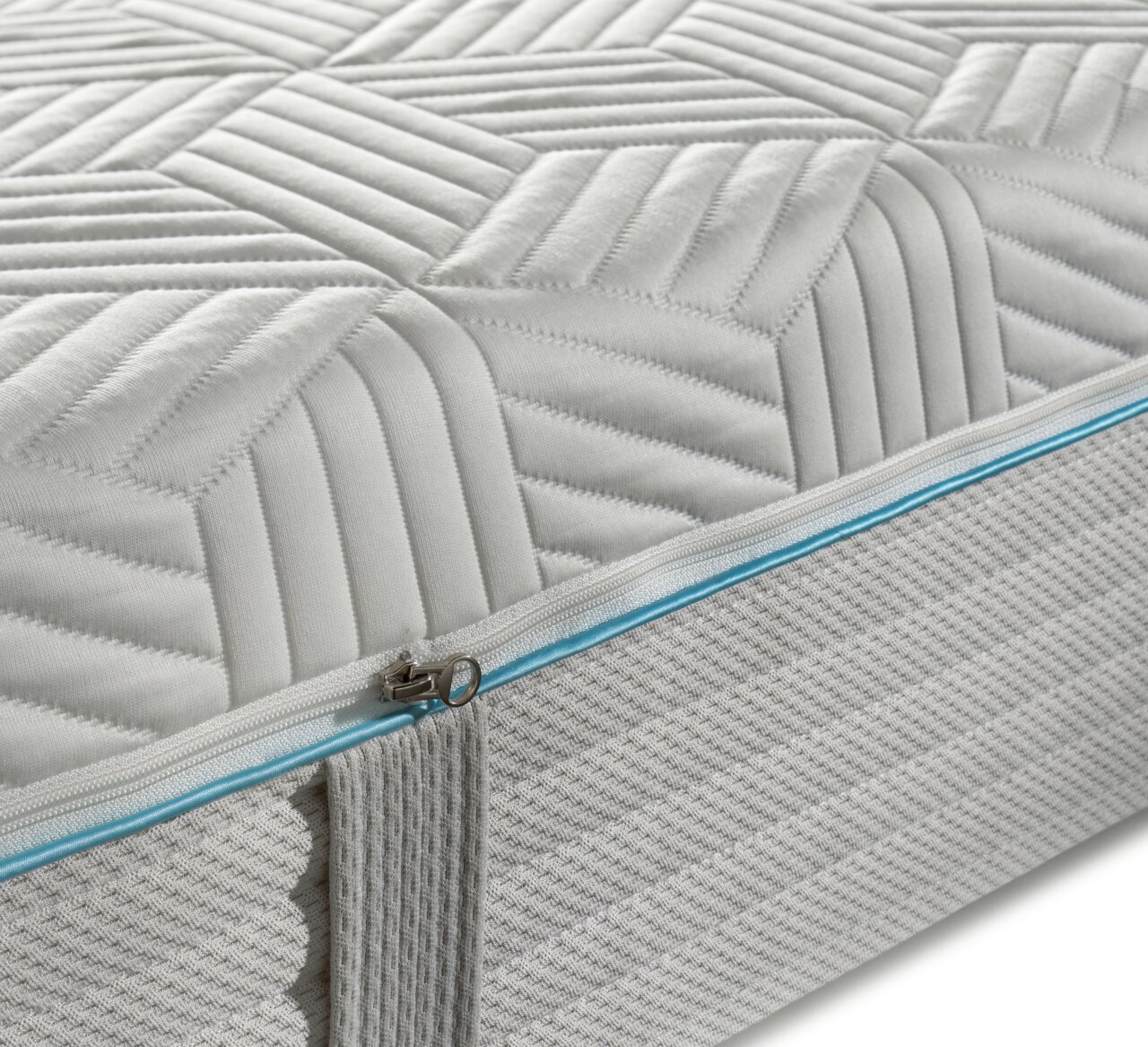 Close-up van een gel-pocketveringmatras met een geometrisch patroon en een blauwe ritssluiting.