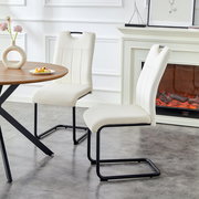 Zwei moderne Esszimmerstühle in Cremeweiß mit gepolsterter Sitz- und Rückenfläche und schwarzem Freischwinger-Metallgestell neben einem runden Holztisch, seitliche Perspektive im hellen Wohnraum mit Kamin im Hintergrund