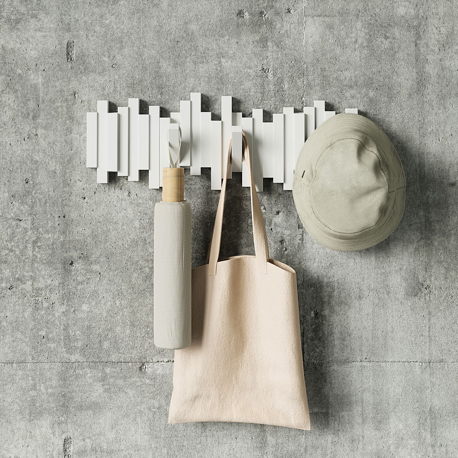Moderne Wandgarderobe mit geometrischem Design, frontal fotografiert, mit Hut, Tasche und Flasche behängt.