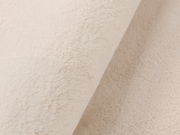 Nahaufnahme eines beigen Fellteppichs in diagonaler Perspektive