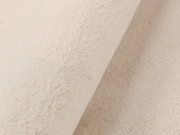 Nahaufnahme eines beigen Fellteppichs in diagonaler Perspektive