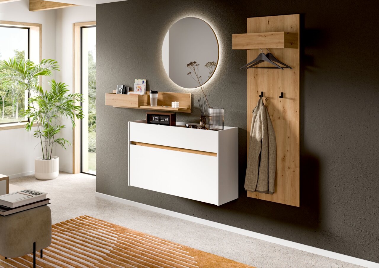 MID.YOU Spiegel DRIVE Modernes Flur-Set mit schwebender weißer Kommode, Holz-Wandpaneel mit Haken und Kleiderbügeln, Ablageboard und rundem Spiegel an dunkler Wand, perspektivisch in leichter Schrägansicht von vorne.