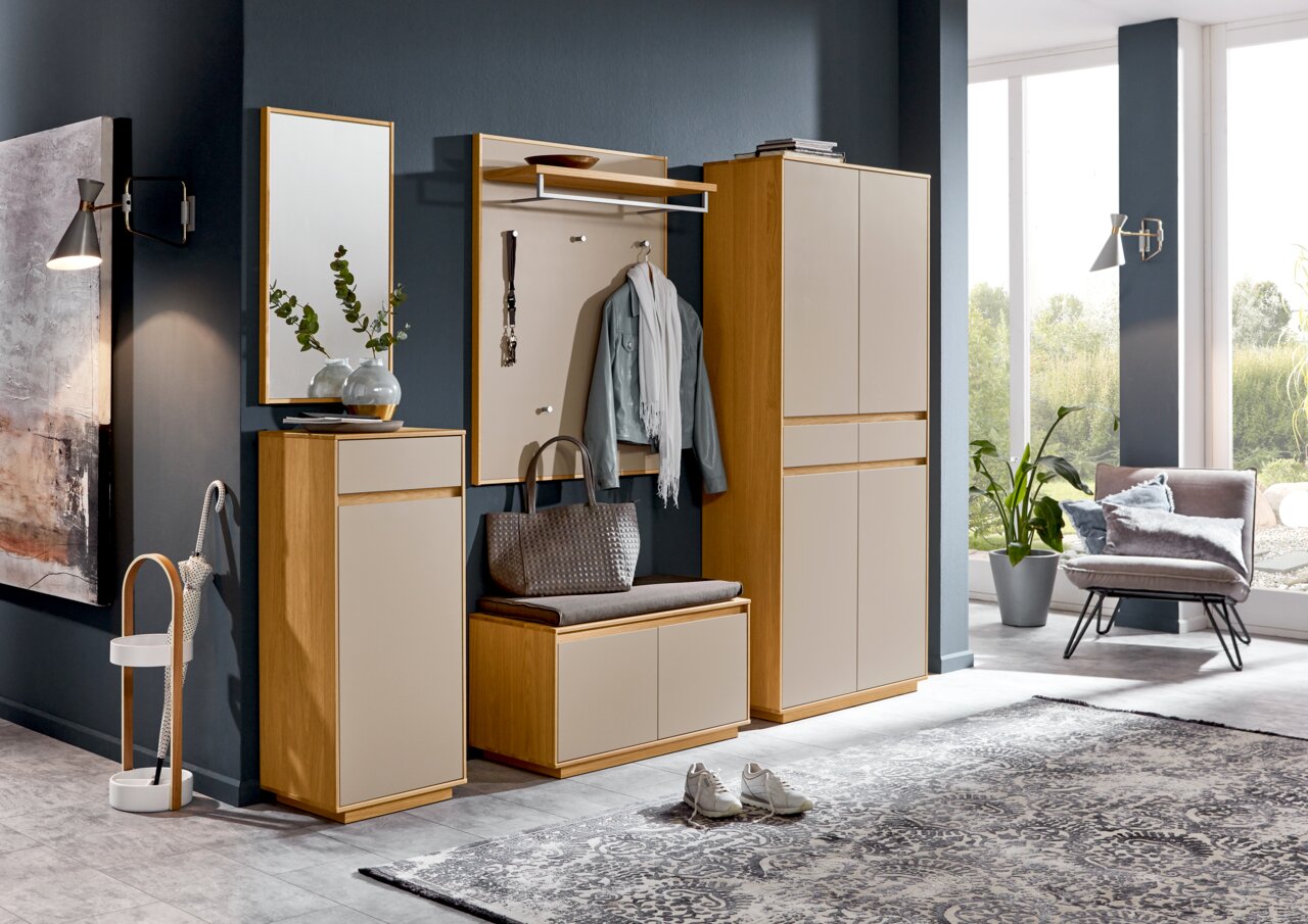 Moderne Garderobeneinrichtung mit Spiegel, Garderobenpaneel, Schuhschrank und Sitzbank in Holzoptik, seitliche Perspektive.