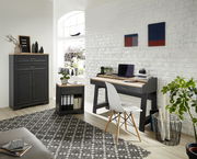 Moderne Büromöbel in einem hellen Raum, bestehend aus einem grauen Aktenschrank, einem Rollcontainer und einem Schreibtisch mit Dekorationen, aus der Perspektive von vorne betrachtet.