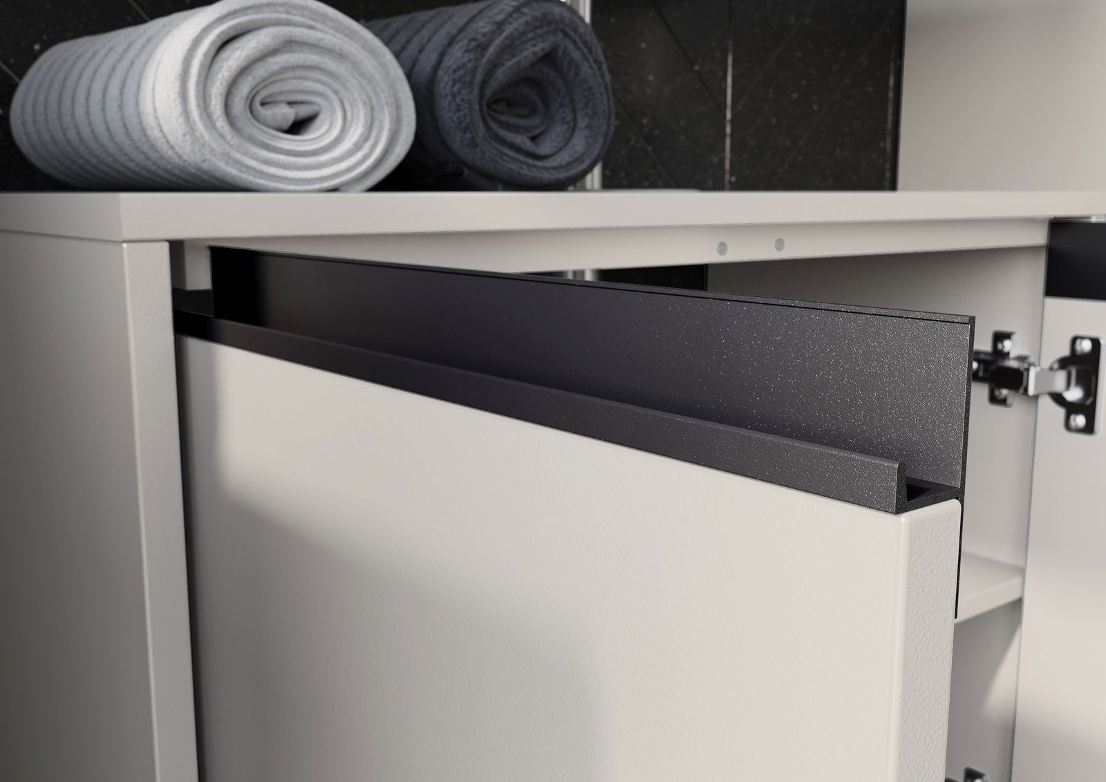 Nahaufnahme eines geöffneten Waschbeckenunterschranks mit modernen, minimalistischen Linien und zwei gerollten Handtüchern auf der Oberseite.