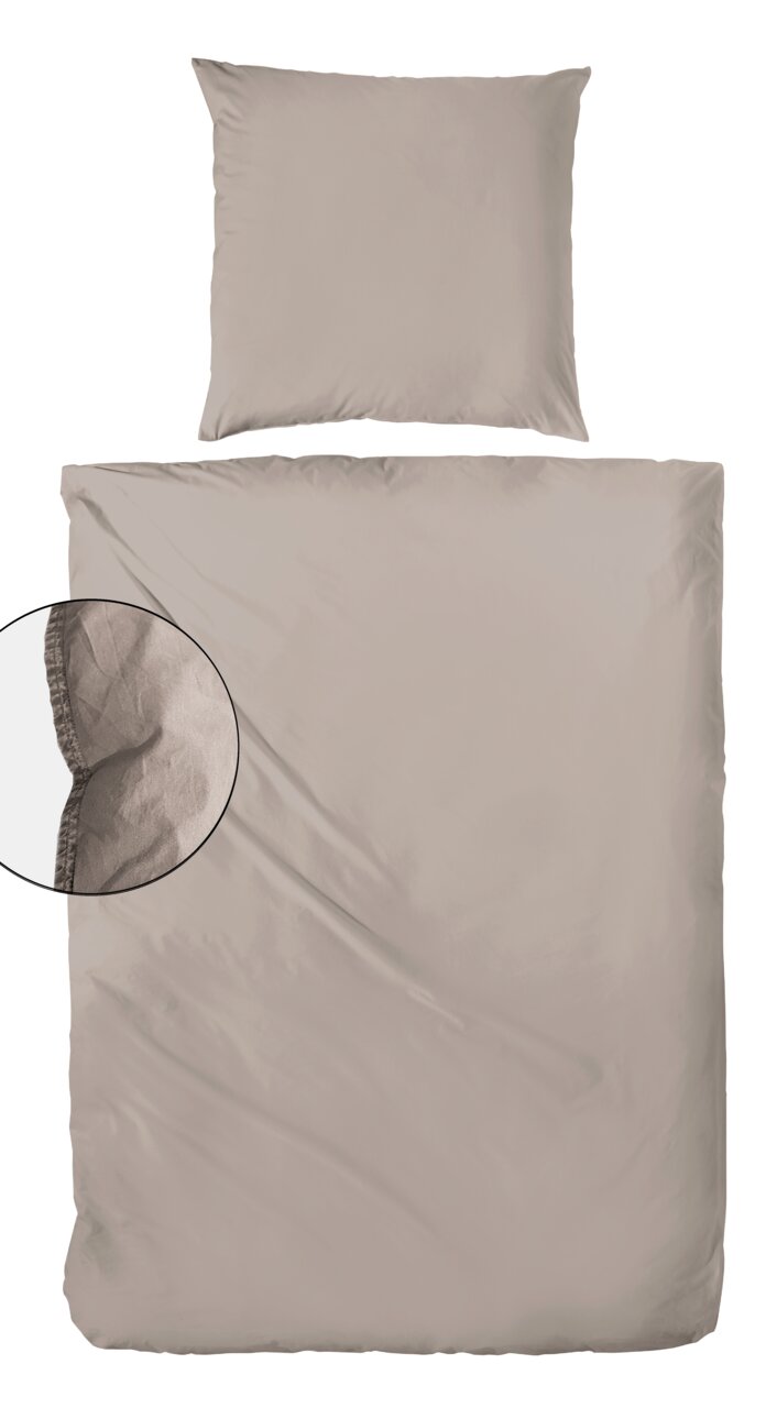 Bettwäsche-Set in Beige, bestehend aus einem Kissenbezug und einem Bettdeckenbezug, aus der Vogelperspektive fotografiert.