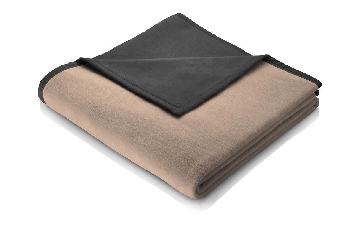 Gefaltete Decke in Beige und Dunkelgrau, von schräg oben fotografiert.