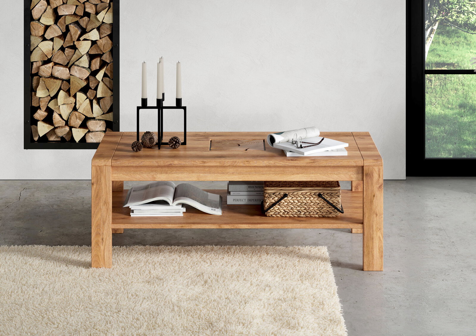 Massiver Couchtisch aus hellem Holz mit Ablagefach, dekoriert mit Kerzenhalter, Büchern und Korb, frontal in leichter Schrägansicht im Wohnzimmer.