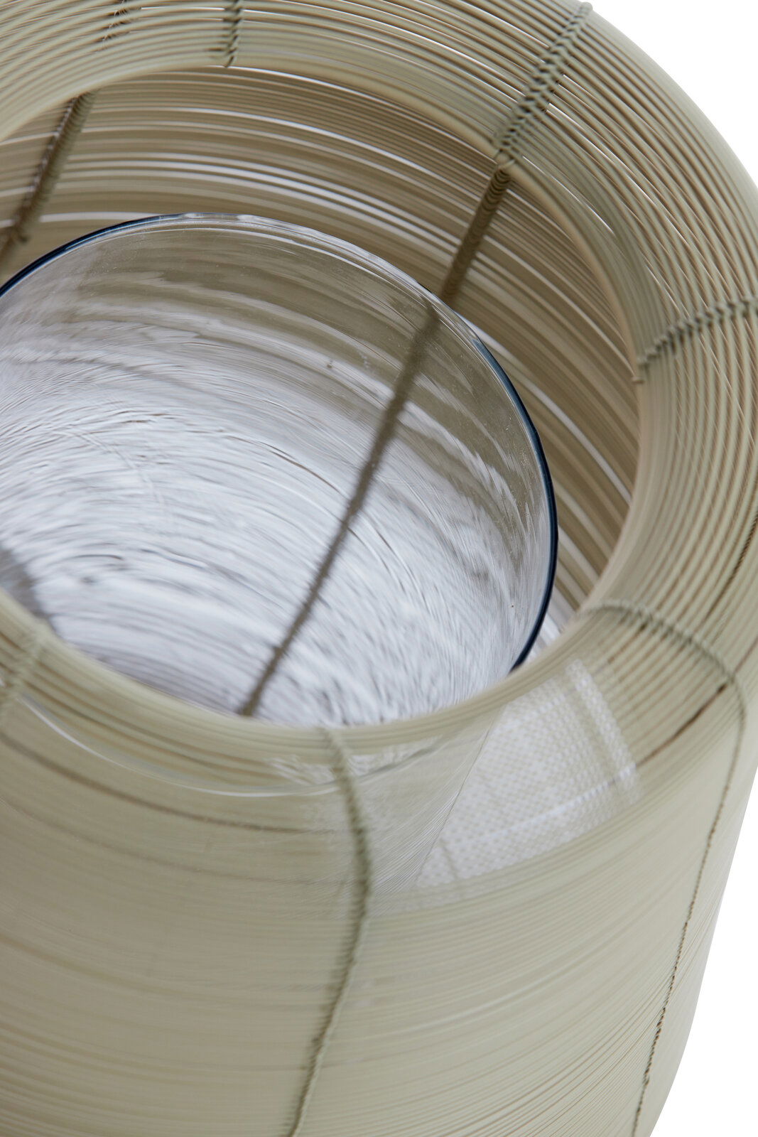 Nahaufnahme eines Windlichts aus geflochtenem Material mit Glaszylinder, von oben betrachtet.